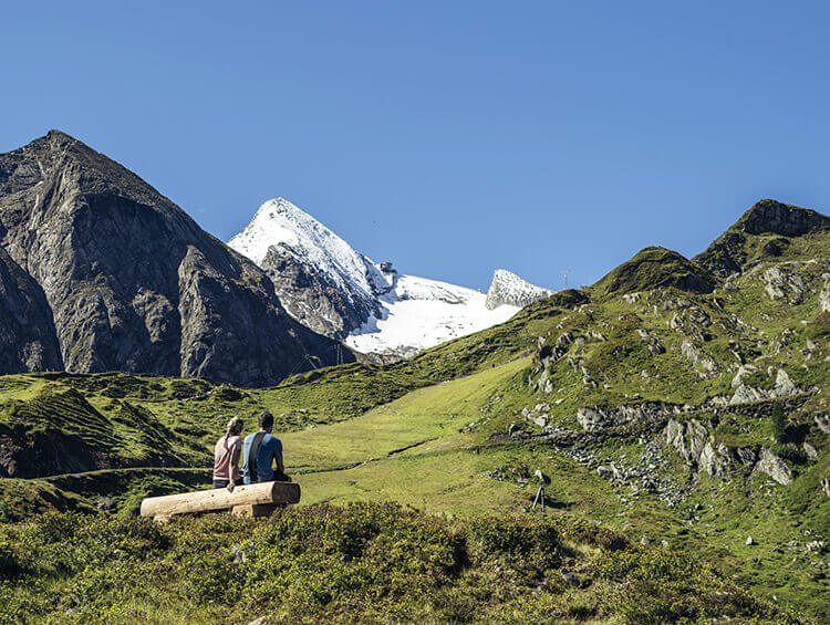 Zwei Personen auf einer Bank im Gebirge