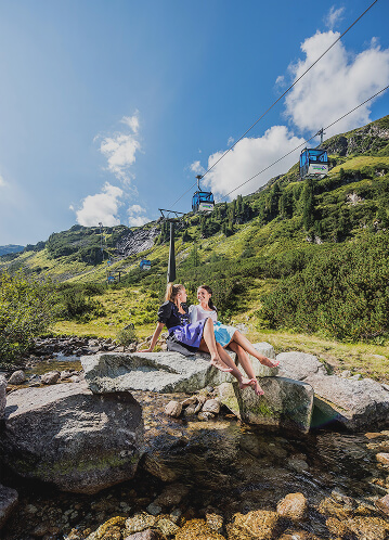 Zwei Frauen vor einer Gondelbahn