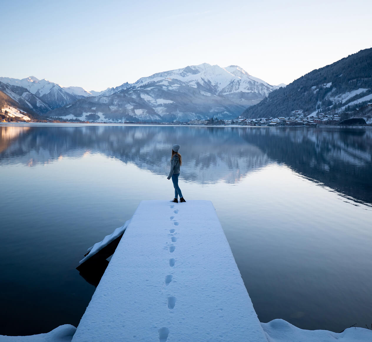Frau steht auf einem Steg am verschneiten Zeller See